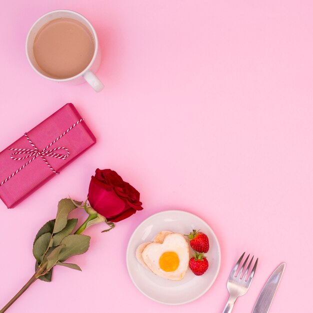 Arrangement of romantic breakfast with rose and present