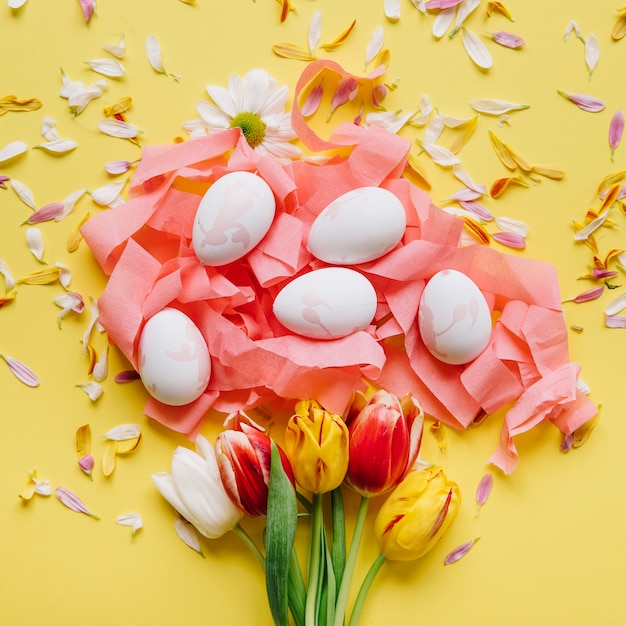 Free photo arrangement of tulips and colored eggs