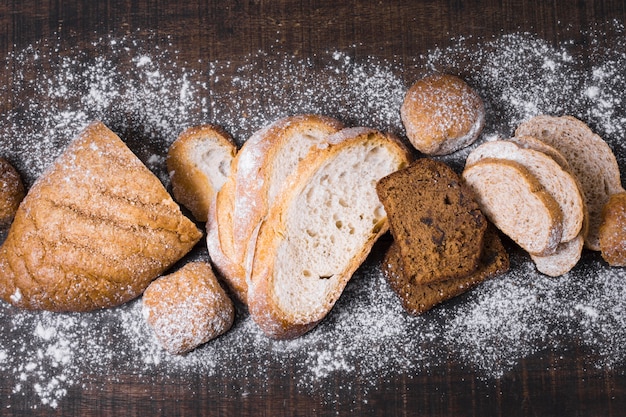 Arrangement of various types of bread and flour top view