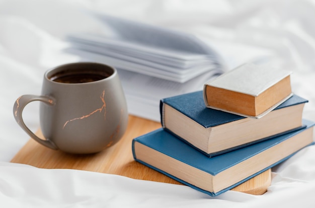 Arrangement with books and cup on board