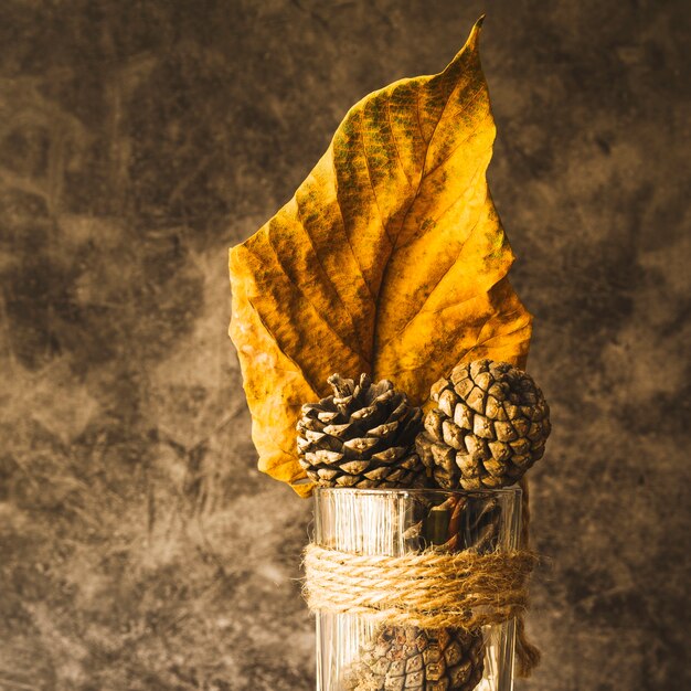 Free photo arrangement with dried yellow leaf and cones