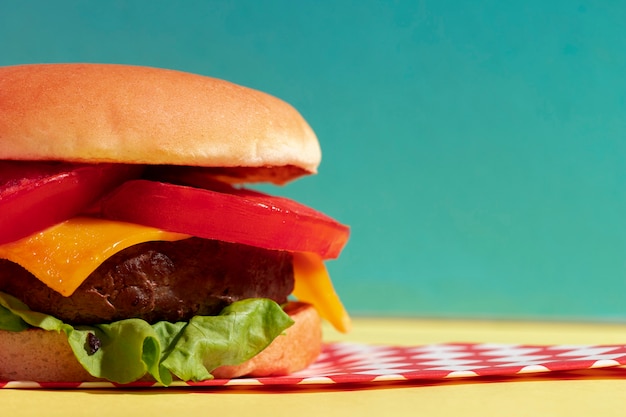 Free photo arrangement with half cheeseburger and blue background