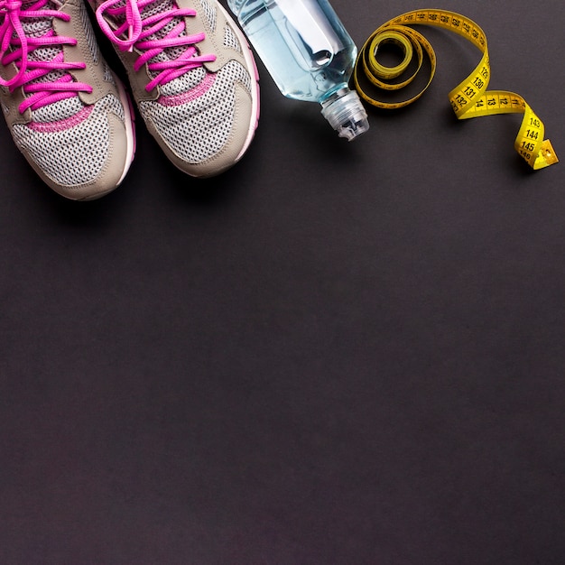 Free photo arrangement with running shoes and water bottle