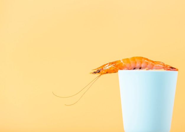 Arrangement with shrimp on cup with yellow background