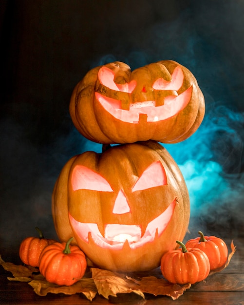 Free photo arrangement with spooky carved pumpkins