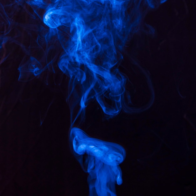 Art of bright blue smoke moving upward on black background