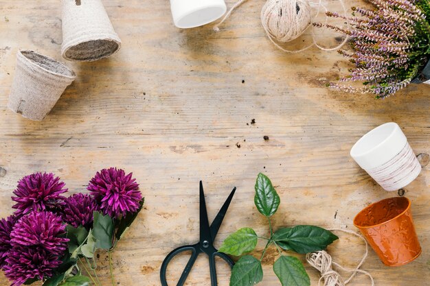 Free Photo artificial chrysanthemum; scissor; empty plant pot on wooden surface