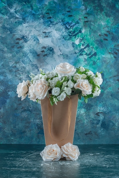 Artificial white flower in a packet , on the blue background.