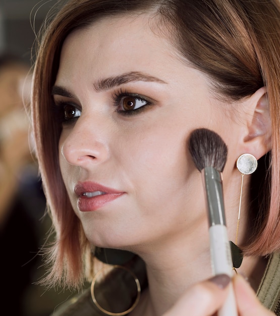 Artist applying blush on model