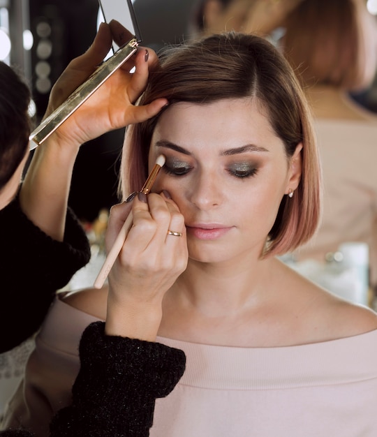 Artist applying eye shadow on model