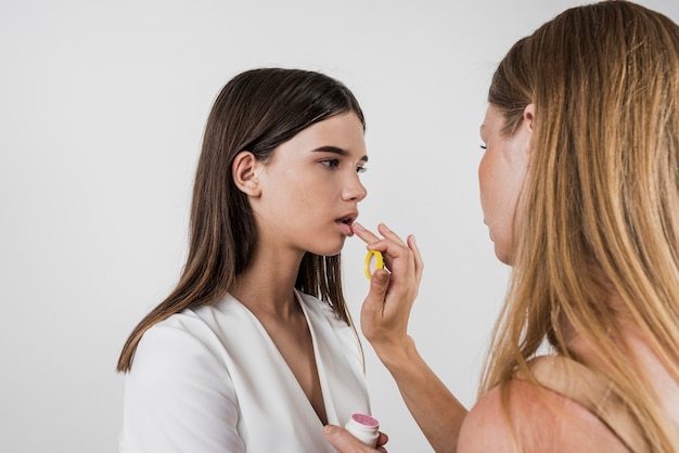 Artist applying lip balm on model