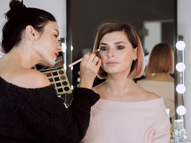 Artist applying make-up on cute model