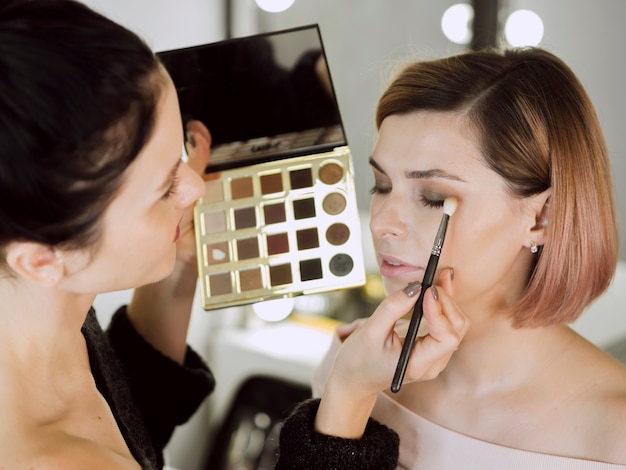 Artist applying make-up on model