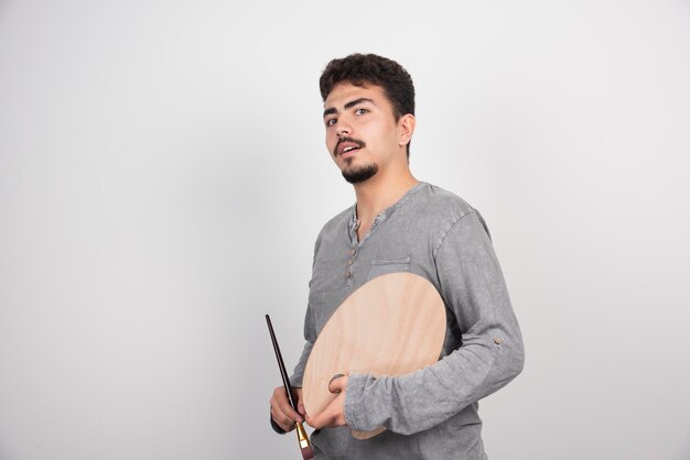 Artist holding his wooden palette board and brush.