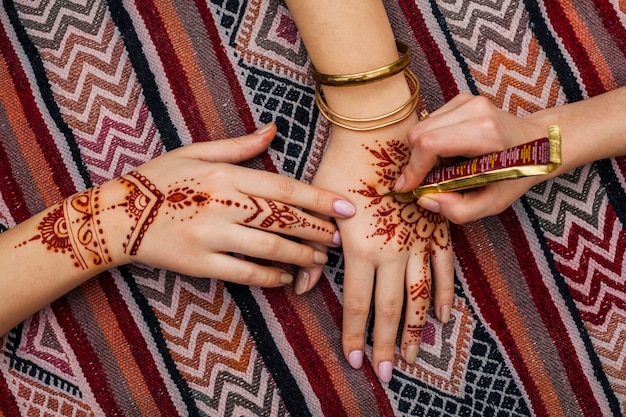 Free Photo artist making mehndi on womans hand on bright table