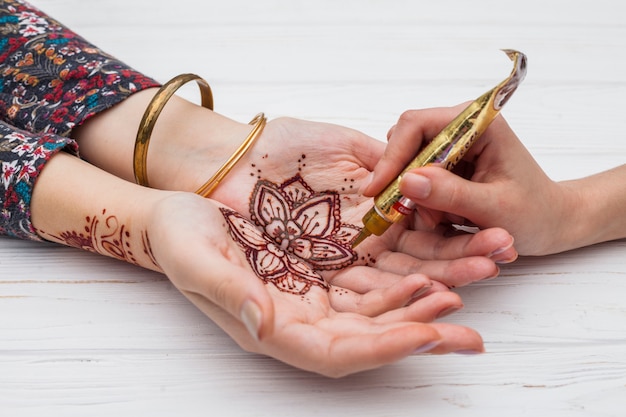 Free Photo artist making mehndi on womans palms