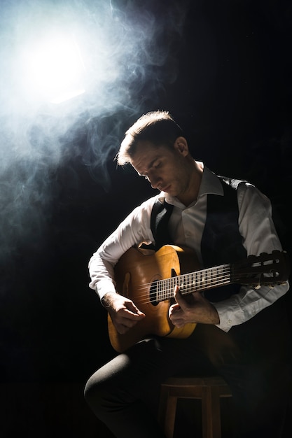 Artist man on stage playing the classical guitar