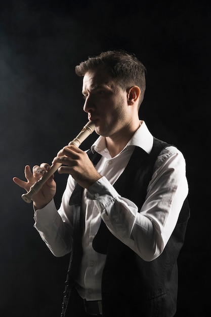 Artist man on stage playing the flute