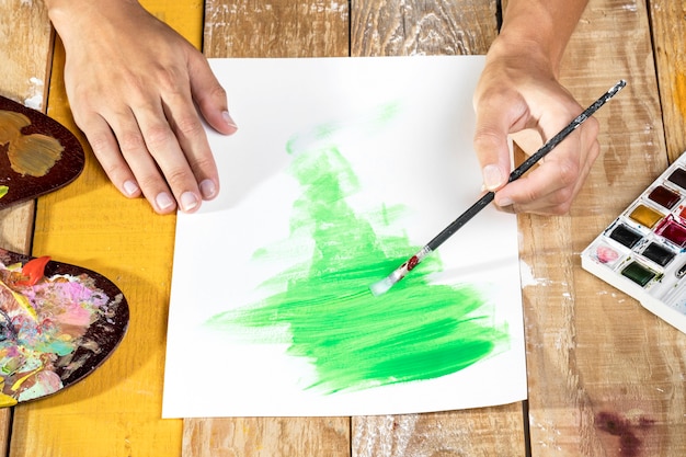 Artist in studio painting with brush