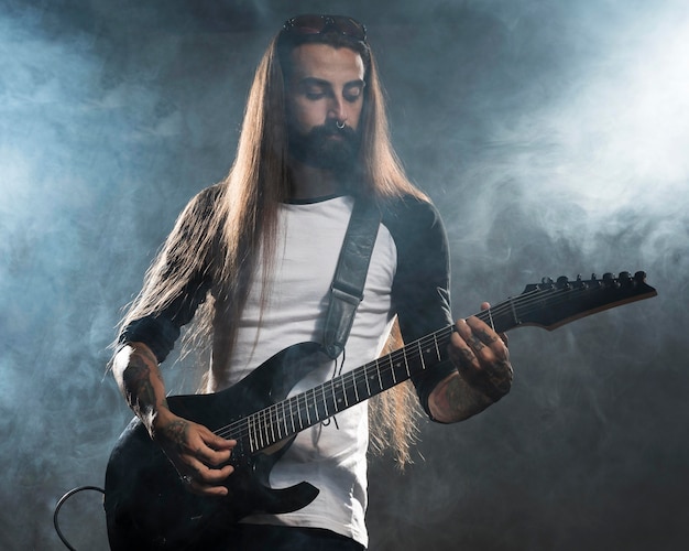 Artist with long hair playing guitar