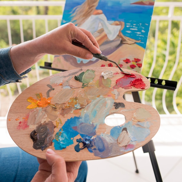 Free Photo artist with palette painting outdoors