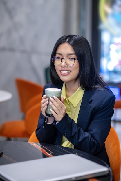 Free photo asian business woman in the office having morning coffee