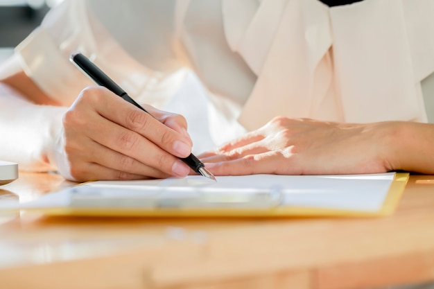 Asian Business woman signing a contract document making a deal.&#xD;