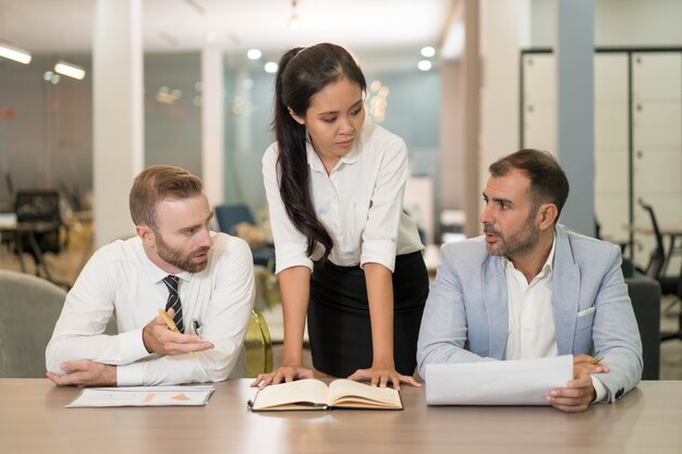 Asian business woman working with coworkers at desk