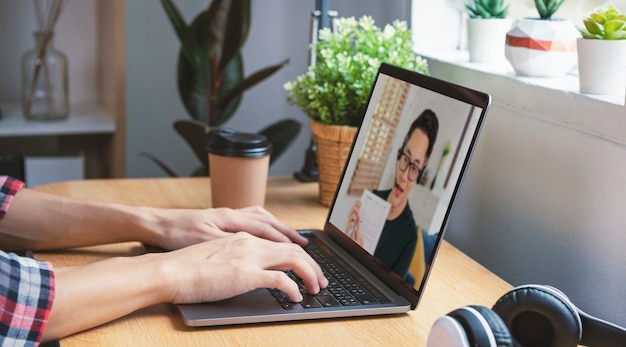 Free photo asian businessman working remotely from home and virtual video conference meeting webinar with colleagues business people. social distancing at home office concept.