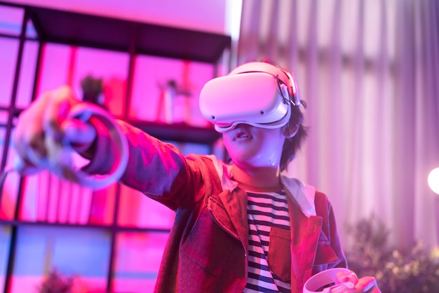 Free photo asian child boy wear vr or virtual reality glassesheadsets standing and playing a video game at living room in front of tv at home in quarantine period technology and innovation concept neon light