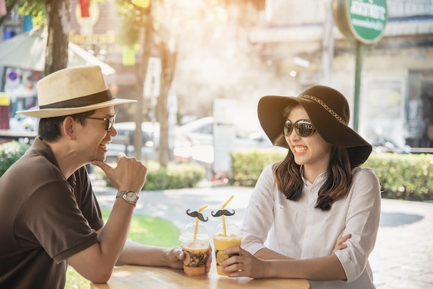 Asian couple enjoy traveling sitting at coffee shop 