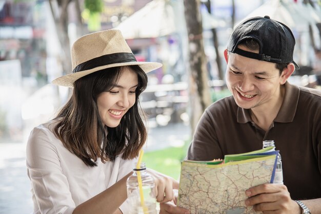 Asian couple enjoy traveling sitting at coffee shop 