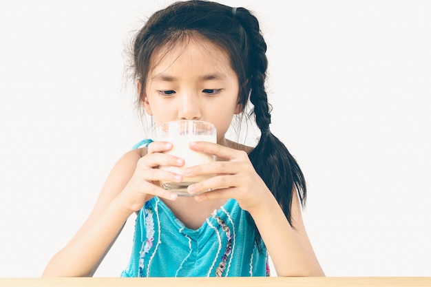 asian girl is drinking a glass of milk over white background