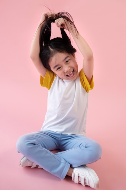 Free photo asian girl posing and pulling her hair