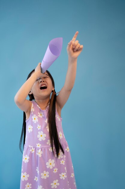 Asian girl using paper as telescope