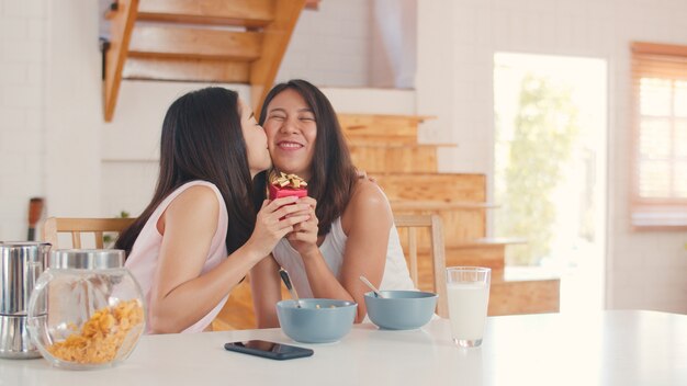 Asian Lesbian lgbtq women couple giving present home