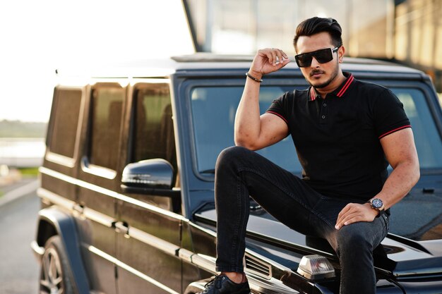 Free photo asian man wear on all black posed near suv car