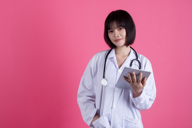 asian medical doctor woman with white lab coat on pink