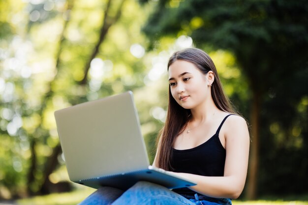 Asian student working with computer laptop outdoor university campus green park concept