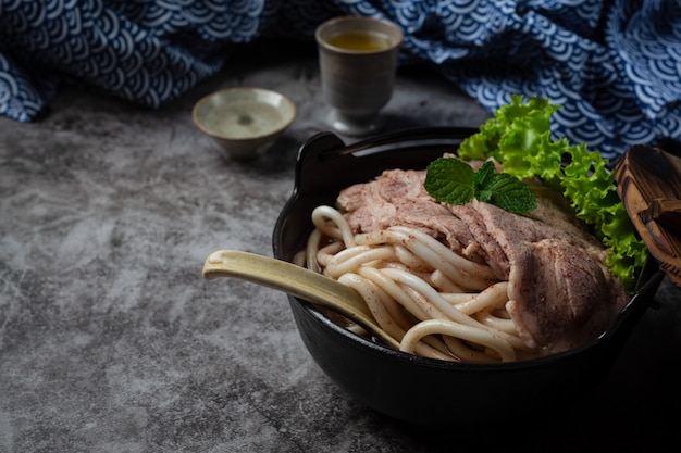 Free photo asian style soup with noodles, pork and green onions closely in a bowl on the table.