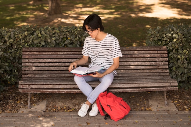 Free Photo asian teen man with textbook on bench