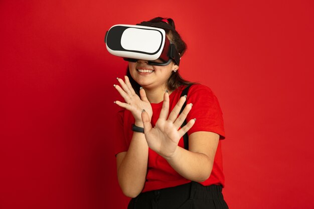 Asian teenager's portrait isolated on red  space