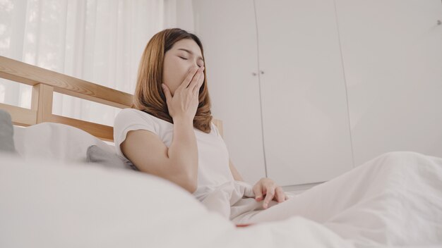 Asian woman dreaming while sleeping on bed in bedroom