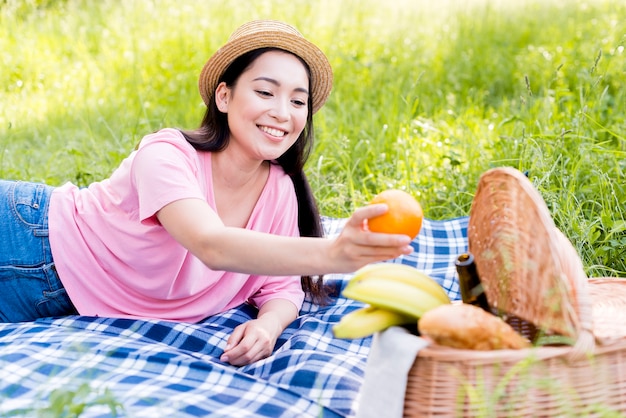 Asian woman holding orange in hand