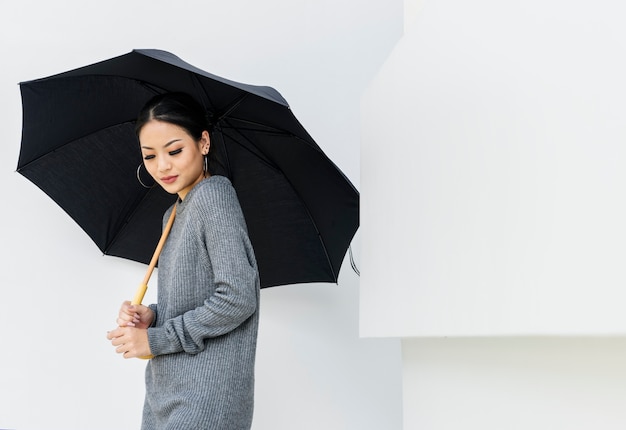 Free photo asian woman holing umbrella on white background