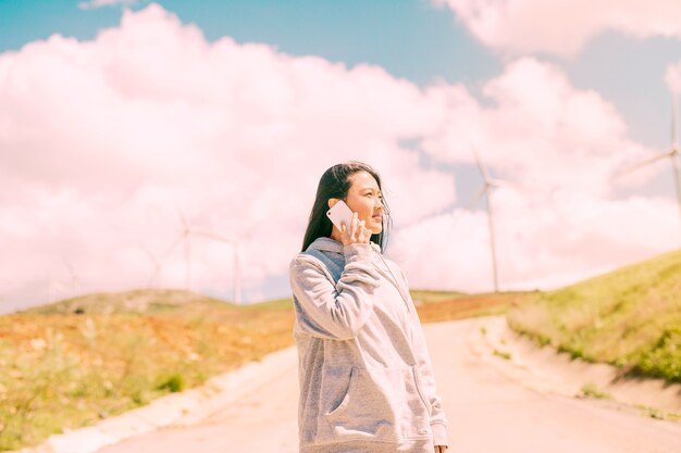 Asian woman phoning on country landscape 