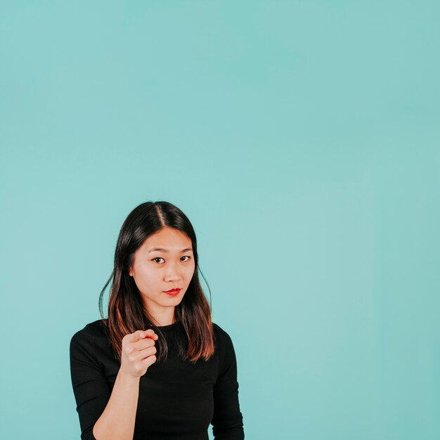 Asian woman pointing at camera