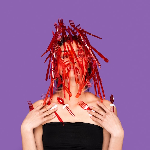 Free photo asian woman posing with red plastic tableware on her