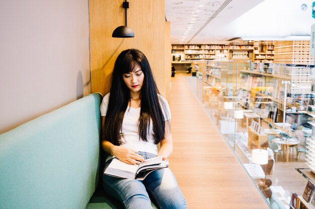 Asian woman reading in book store