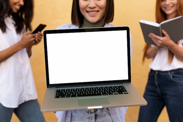 Asian woman showing a blank laptop